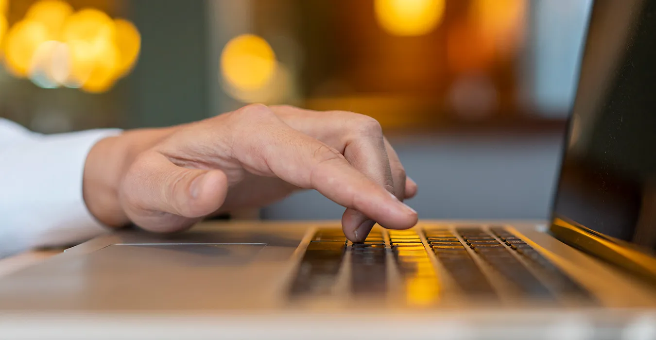 Persona interactuando con pc portátil en un sitio web, resaltando la importancia de la interactividad en el diseño web para mejorar la experiencia del usuario.